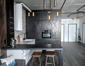 View to the kitchen from the lounge area. Overall dark hues are contrasted by pure white elements, spiced up by blue and turquoise splashes and warmed up by saturated wood and gold.