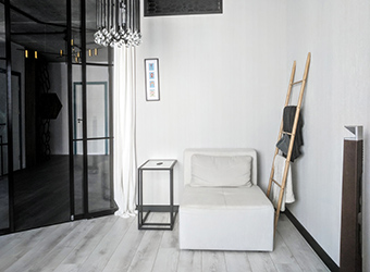 Luxurious crystal and metal black retro chandelier elevates basic glass/metal elements from Ikea. The armchair can be converted into a guest bed and curtains can be drawn over the glass sliding doors for more privacy.