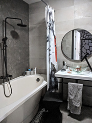 Italian wall tiles combine with natural stone floor mosaic near the bathtub.